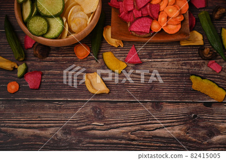 Healthy homemade vegetable chips on wooden table. Healthy homemade vegetable chips on wooden table. 82415005