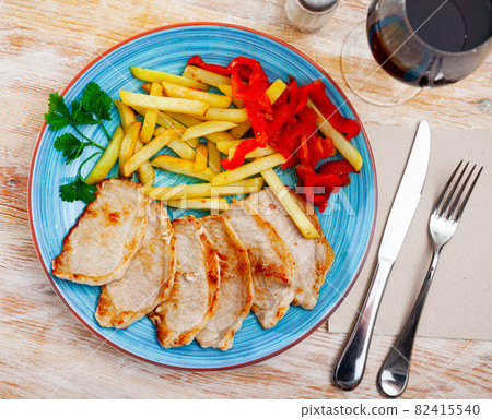 Pork loin with fried potato and pimiento on plate Pork loin with fried potato and pimiento on plate 82415540