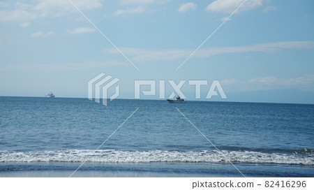 A gentle beach where you can see the ship in the distance 82416296