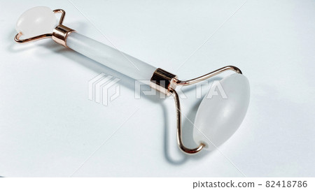 White massage quartz roller for the face close-up isolated on a white background White massage quartz roller for the face close-up isolated on a white background 82418786