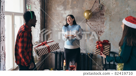 African man giving a birthday gift to friend at party. 82419710