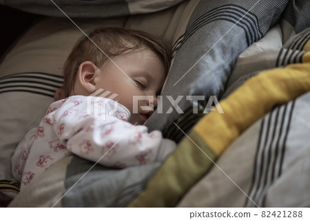 newborn baby sleeping at home in bed 82421288