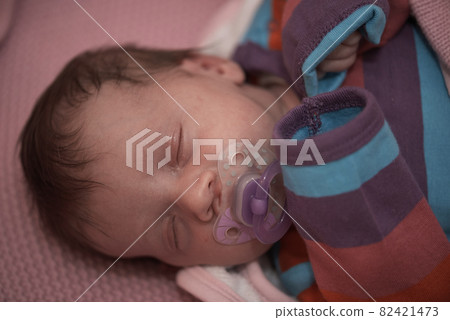 One month newborn baby sleeping in bed One month newborn baby sleeping in bed 82421473