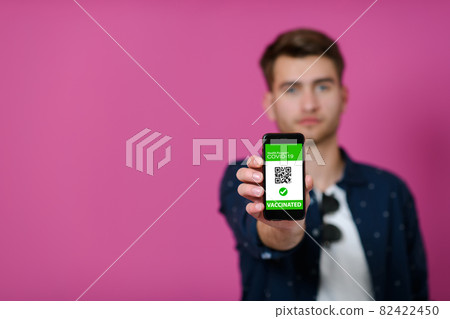 covid passport a young man shows his qr code and covid19 passport on his cell phone covid passport a young man shows his qr code and covid19 passport on his cell phone 82422450