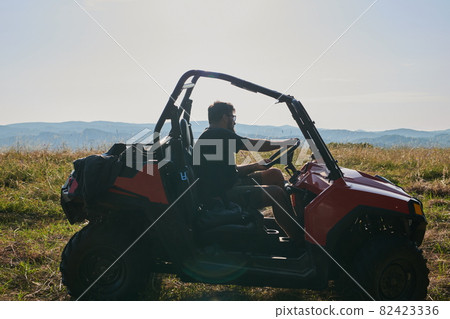 man enjoying beautiful sunny day while driving a off road buggy car man enjoying beautiful sunny day while driving a off road buggy car 82423336