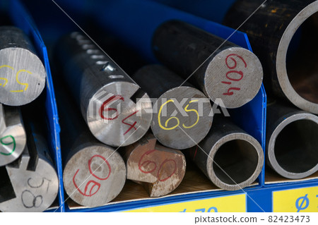 pipes, metal pieces and various metal parts for a CNC machine standing on a shelf 82423473