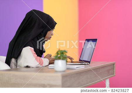 afro girl wearing a hijab is disappointed and sad sitting in her home office and using a laptop afro girl wearing a hijab is disappointed and sad sitting in her home office and using a laptop 82423827