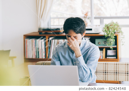 A man whose eyes get tired from teleworking 82424548