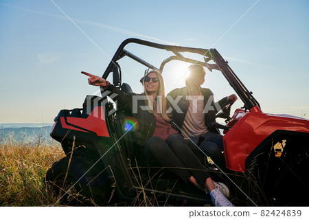 couple enjoying beautiful sunny day while driving a off road buggy couple enjoying beautiful sunny day while driving a off road buggy 82424839