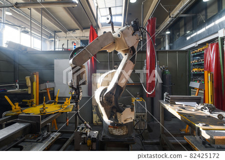 Automatic welding robot mechanical arm is working in the modern automobile parts factory. Automatic welding robot mechanical arm is working in the modern automobile parts factory. 82425172