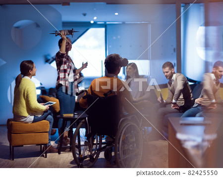 Disabled businessman in a wheelchair at work in modern open space coworking office with team using virtual reality googles drone assistance simulation Disabled businessman in a wheelchair at work in modern open space coworking office with team using virtual reality googles drone assistance simulation 82425550
