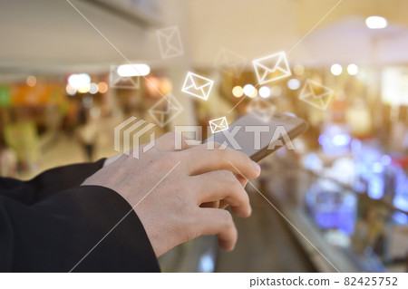 Hand holding using mobile phone with email icon on screen Hand holding using mobile phone with email icon on screen 82425752