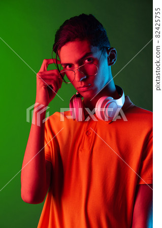 Portrait of young handsome man, student in casual clothes isolated on green vintage studio backgroud. Human emotions concept. 82425755