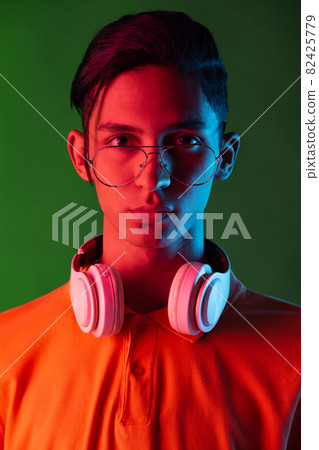 Portrait of young handsome man, student in casual clothes isolated on green vintage studio backgroud. Human emotions concept. Portrait of young handsome man, student in casual clothes isolated on green vintage studio backgroud. Human emotions concept. 82425779