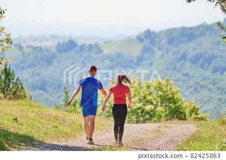 couple enjoying in a healthy lifestyle while jogging on a country road couple enjoying in a healthy lifestyle while jogging on a country road 82425863