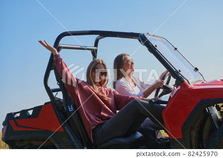girls enjoying a beautiful sunny day while driving an off-road car girls enjoying a beautiful sunny day while driving an off-road car 82425970