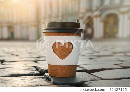 paper cup of natural coffee with carved white heart on on Palace Square in St. Petersburg paper cup of natural coffee with carved white heart on on Palace Square in St. Petersburg 82427135