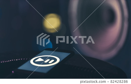 Phone with music listening icon on screen on dark background, copy space. 82428286