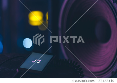 Phone with music listening icon on screen on dark background, copy space. Phone with music listening icon on screen on dark background, copy space. 82428310