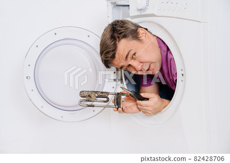 repairman of washing machine holds tubular electric heater and screwdriver repairman of washing machine holds tubular electric heater and screwdriver 82428706