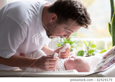 Young caucasian father hugging his newborn daughter 82429179