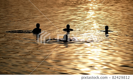 Silhouettes of bathing people on the city lake. Silhouettes of bathing people on the city lake. 82429812