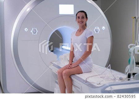 Young female patient sitting in magnetic resonance imaging machine 82430595