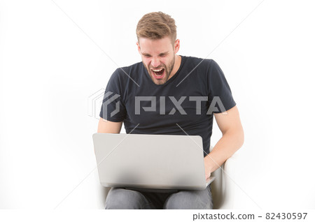 Furious man at computer monitor isolated on white. 82430597
