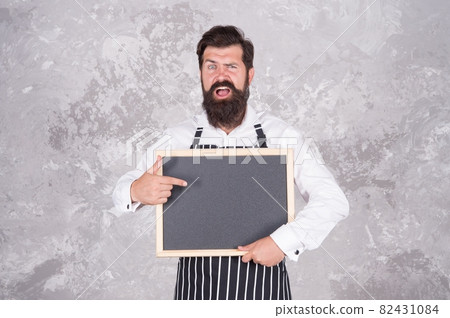 Caucasian hipster male cook with surprised face pointing Caucasian hipster male cook with surprised face pointing 82431084