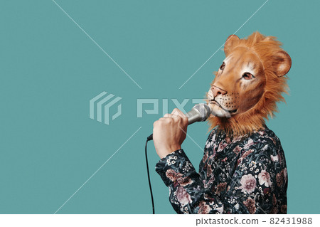 man wearing a lion mask speaks into a microphone 82431988