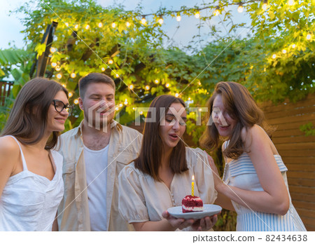 Birthday party with friends. Make a wish. Birthday cake with candle. Anniversary celebration 82434638