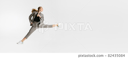 Drinking coffee on the go. Female worker isolated over white studio background. Ballet style movement 82435084