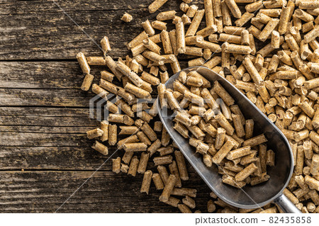Wooden pellets in scoop. Ecological heating. 82435858