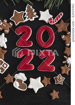 Inscription 2022 surrounded ginger biscuits glazed sugar icing. Christmas cookies stars, fir-tree and other. Vertical frame Inscription 2022 surrounded ginger biscuits glazed sugar icing. Christmas cookies stars, fir-tree and other. Vertical frame 82435981