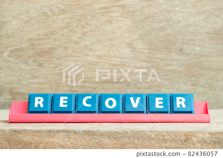 Tile alphabet letter with word recover in red color rack on wood background Tile alphabet letter with word recover in red color rack on wood background 82436057