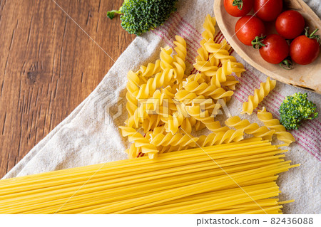 Two types of pasta, petit tomatoes and broccoli seen from a bird's-eye view 82436088