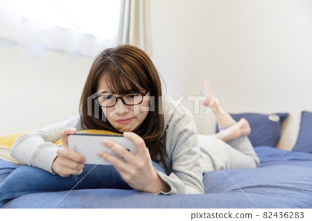 在床上看智能手機的女人 在床上看智能手機的女人 82436283