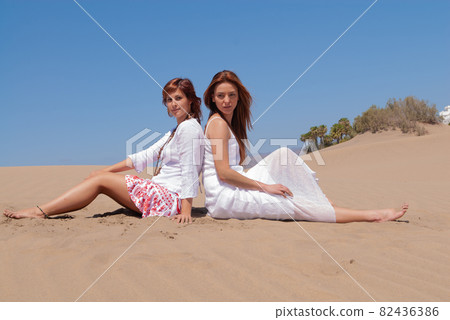 women in white dress in desert dunes  82436386