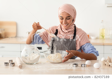 Happy Muslim Woman In Hijab Baking In Kitchen, Preparring Dough For Cookies 82437189