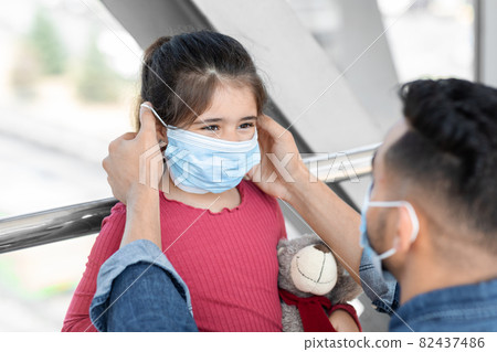Caring Dad Adjusting Protective Medical Mask On Little Daughter's Face In Airport 82437486