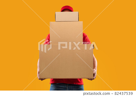 Unrecognizable Courier Holding Many Cardboard Boxes Delivering Packages, Yellow Background 82437539