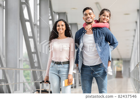 Portrait Of Happy Loving Middle Eastern Family Walking With Suitcases In Airport Portrait Of Happy Loving Middle Eastern Family Walking With Suitcases In Airport 82437546