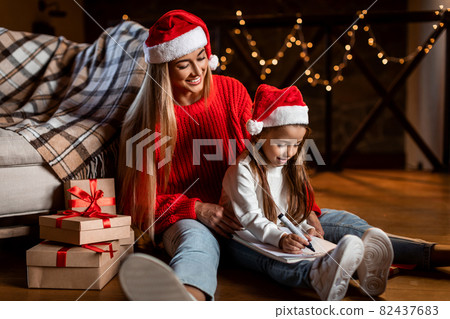 Portrait of cute girl writing letter to Santa 82437683