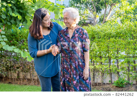 Asian elderly woman with caregiver walking with happy in nature park. Asian elderly woman with caregiver walking with happy in nature park. 82441262