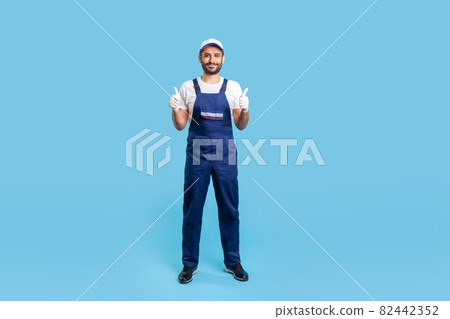 Portrait of worker man in uniform on blue background. 82442352