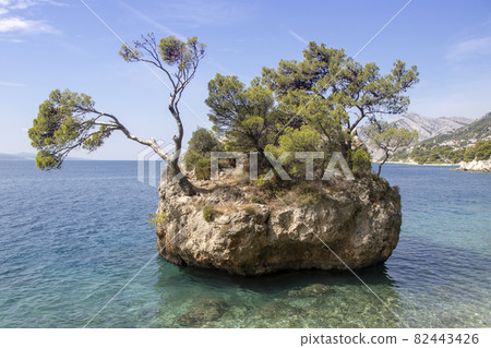 Small stone islet on Punta Rata beach in Brela 82443426