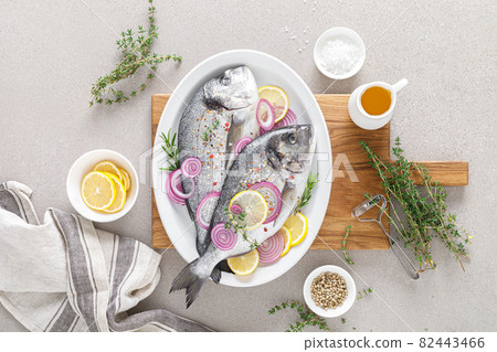 Fresh whole dorada fish and ingredients for cooking. Raw sea bream with spices on white background. Healthy food, diet. Top view with copy space. Fresh whole dorada fish and ingredients for cooking. Raw sea bream with spices on white background. Healthy food, diet. Top view with copy space. 82443466