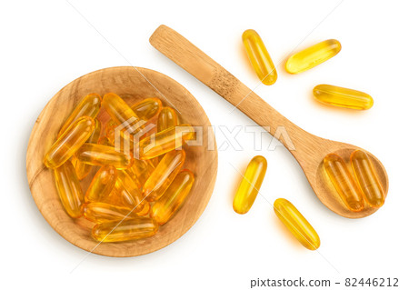 Fish oil capsules in wooden bowl isolated on white background with clipping path and full depth of field. Top view. Flat lay Fish oil capsules in wooden bowl isolated on white background with clipping path and full depth of field. Top view. Flat lay 82446212