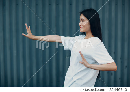 Asian young woman doing qigong Taijiquan exercise summer outdoor Asian young woman doing qigong Taijiquan exercise summer outdoor 82446740