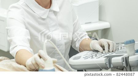 Doctor operating Ultrasound scanner for patient diagnostic 82448087